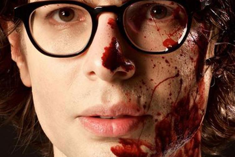 Simon Amstell with blood on his face to promote his film Carnage